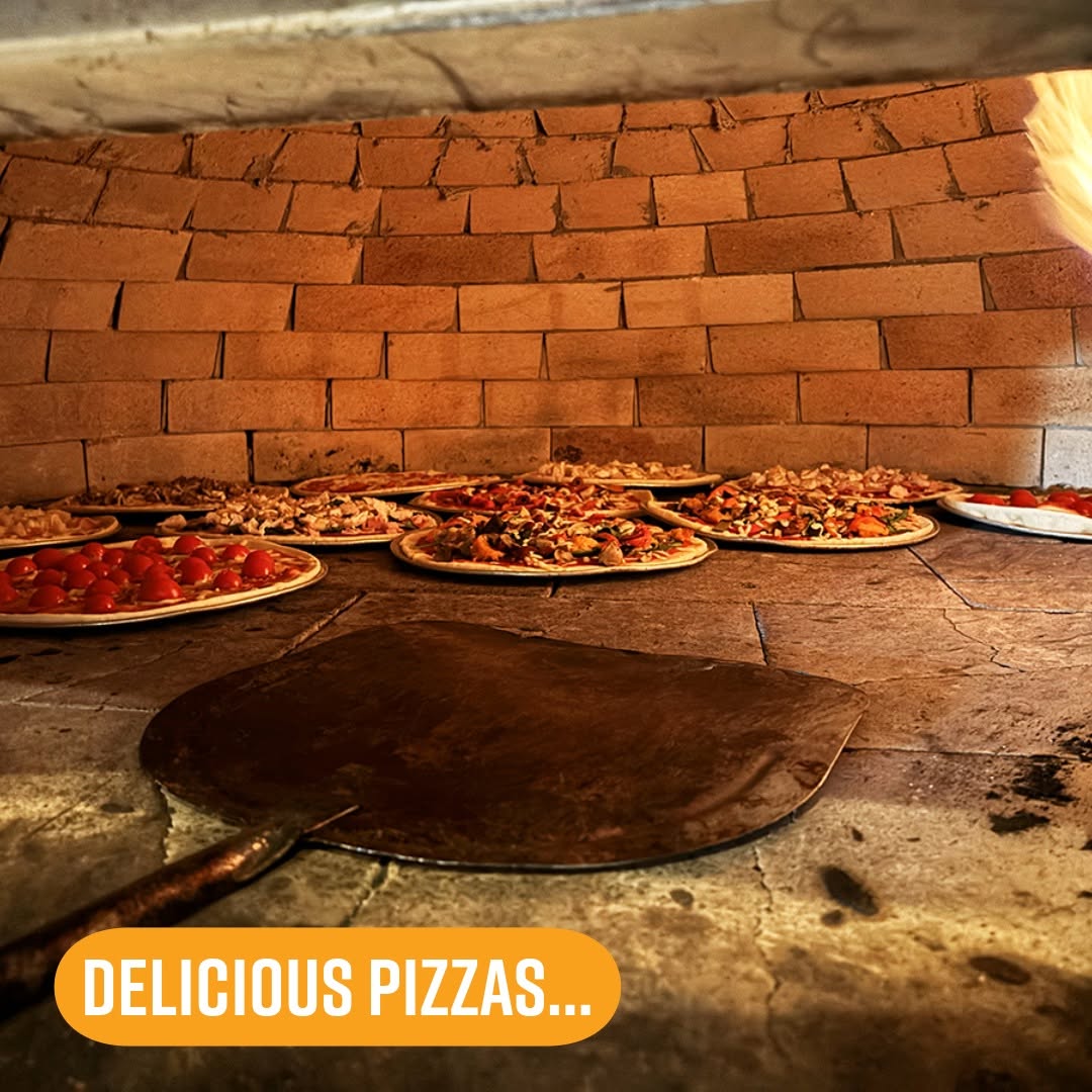 Pizzas cooking in the wood-fired oven